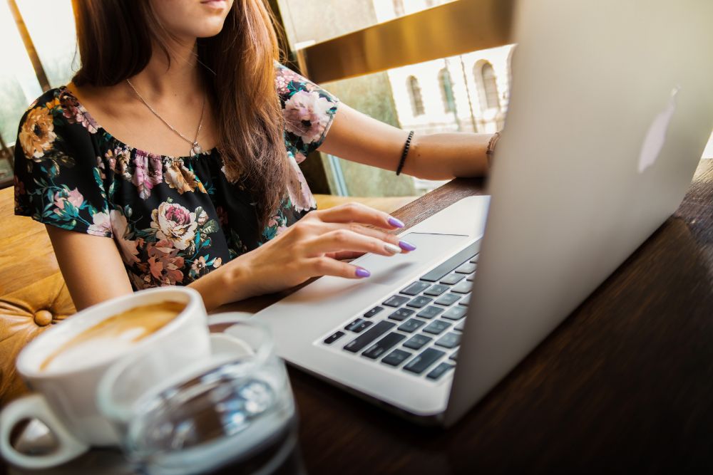 Freelance Social Media Marketing Consultant working on her laptop from a cafe