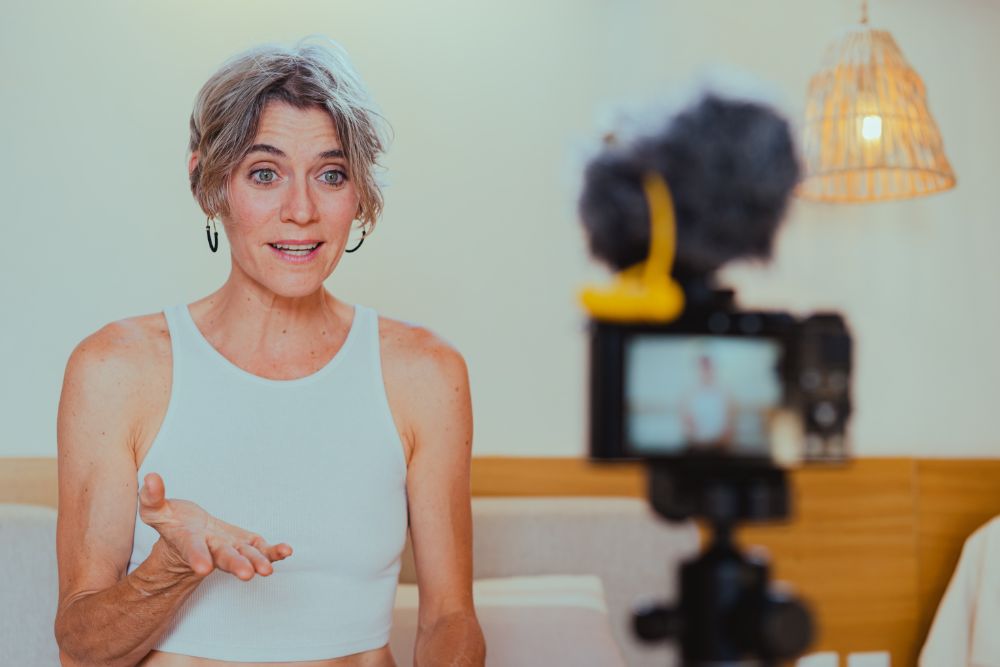 Woman speaks in front of a camera and light ring presenting SEO courses to customers